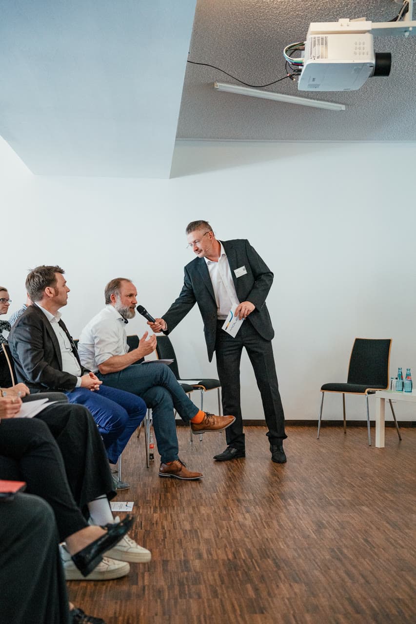 Dirk Brueckner holding a microphone to a participant during a workshop conversation